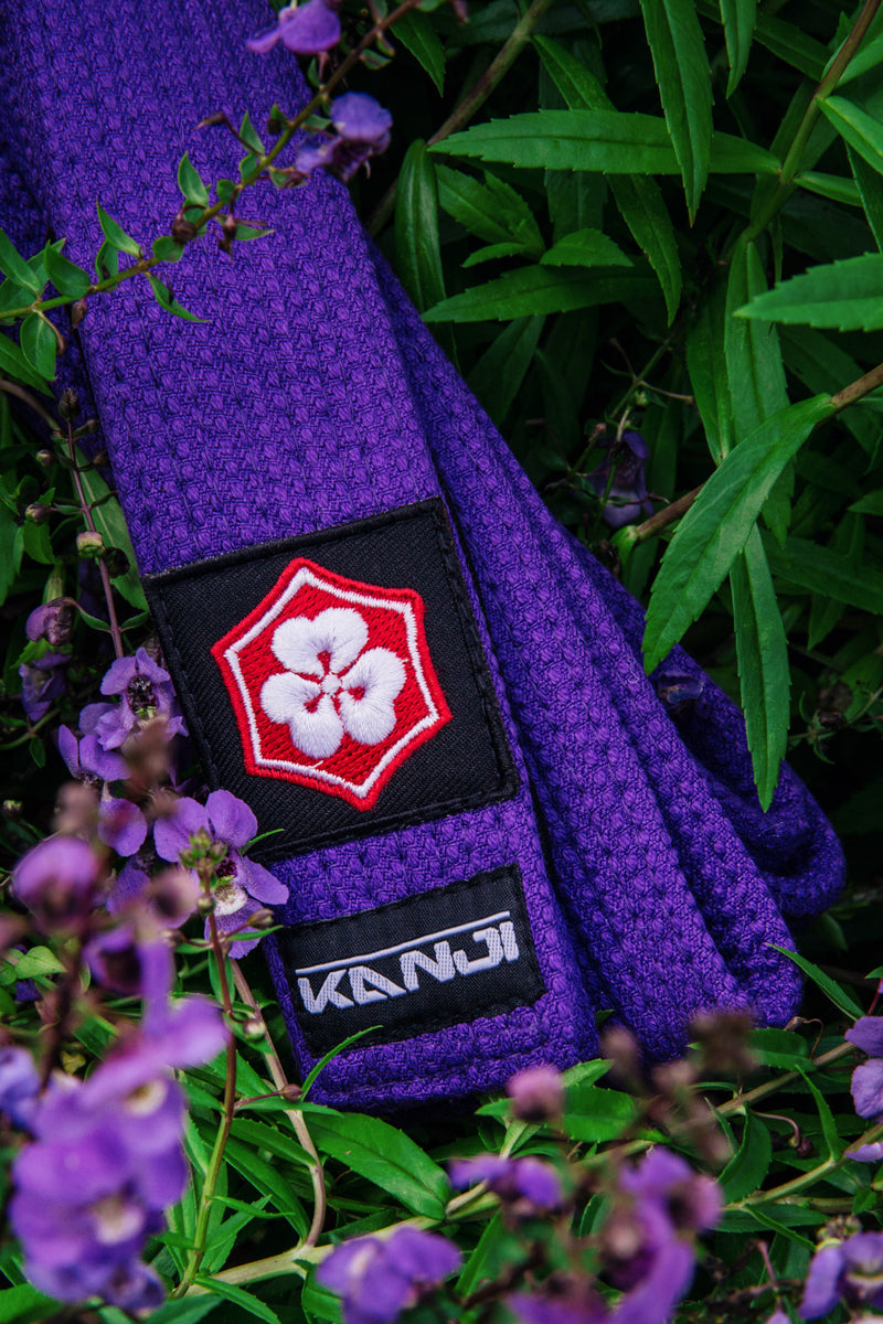 Purple KANJI KATANA BJJ belt among purple flowers