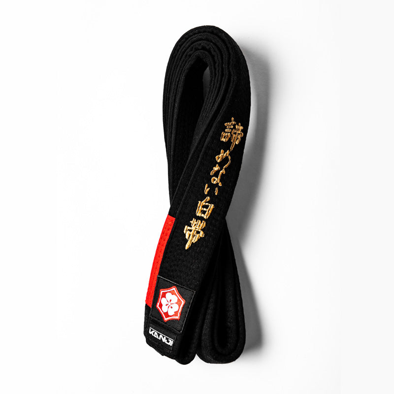 A WHITE BELT WHO NEVER QUIT EDITION — ORIGINAL black belt with red bar and gold embroidery