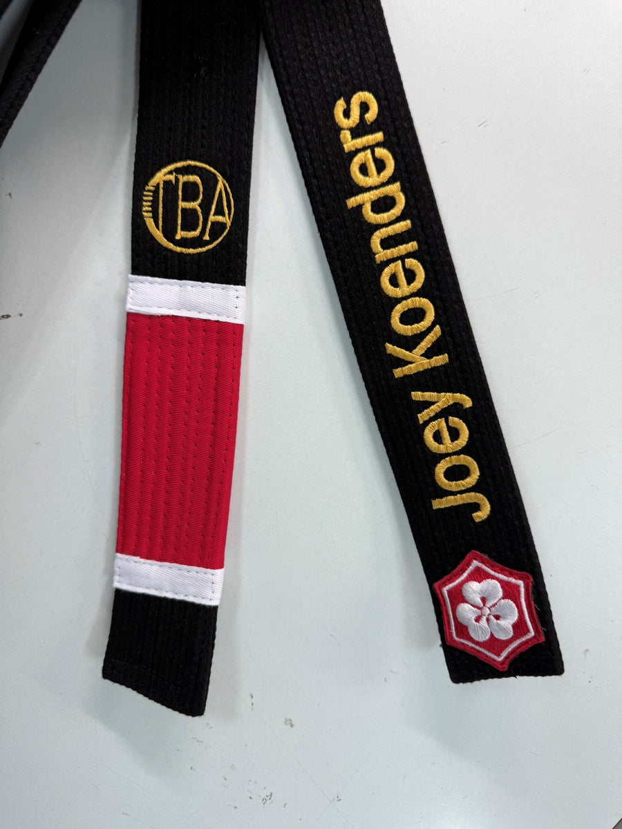 Gold BA academy logo above a red rank bar and Joey Koenders embroidered above the KANJI logo on the opposite belt end