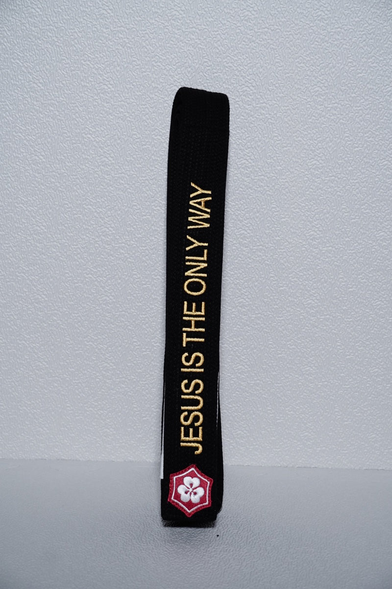 Gold English phrase JESUS IS THE ONLY WAY embroidered along a black belt above the KANJI logo